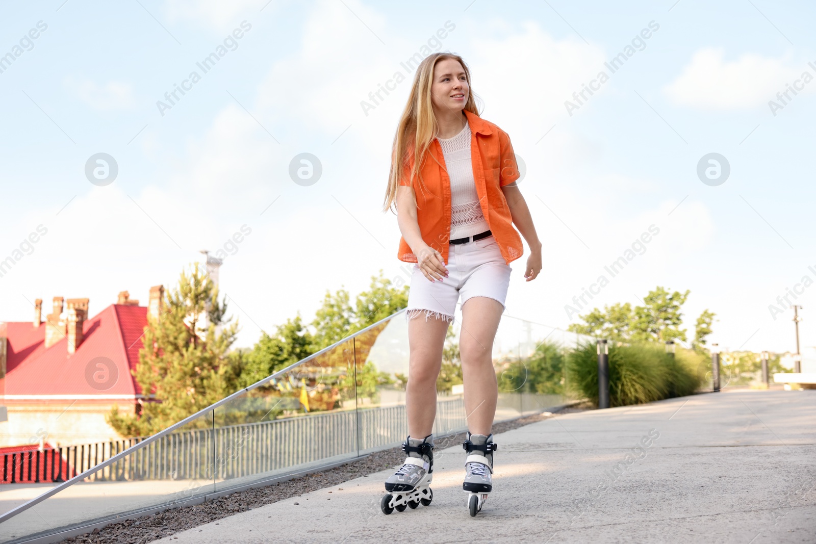 Happy woman roller skating on city street Photo of Happy woman roller skating on city street