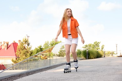 Photo of Happy woman roller skating on city street