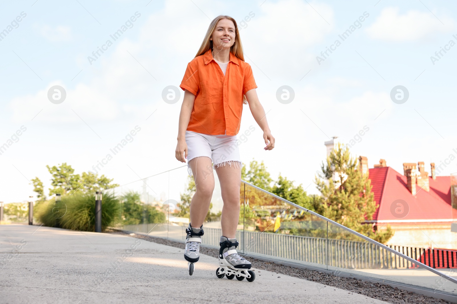 Happy woman roller skating on city street Photo of Happy woman roller skating on city street