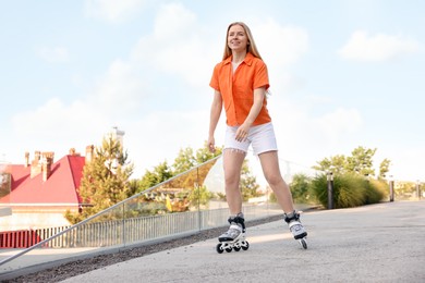 Photo of Happy woman roller skating on city street