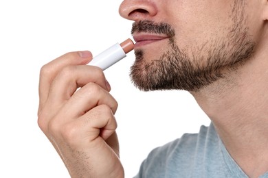 Photo of Man applying lip balm onto his lips on white background, closeup