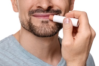 Photo of Man applying lip balm onto his lips on white background, closeup