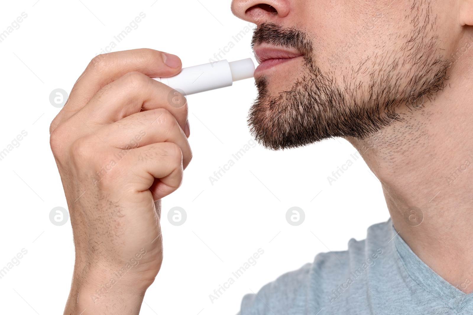 Man applying lip balm onto his lips on white background, closeup Photo of Man applying lip balm onto his lips on white background, closeup