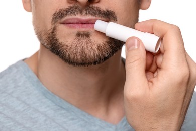 Photo of Man applying lip balm onto his lips on white background, closeup