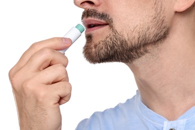 Photo of Man applying lip balm onto his lips on white background, closeup