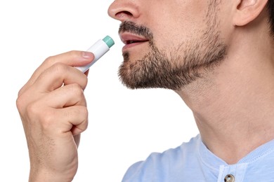 Photo of Man applying lip balm onto his lips on white background, closeup