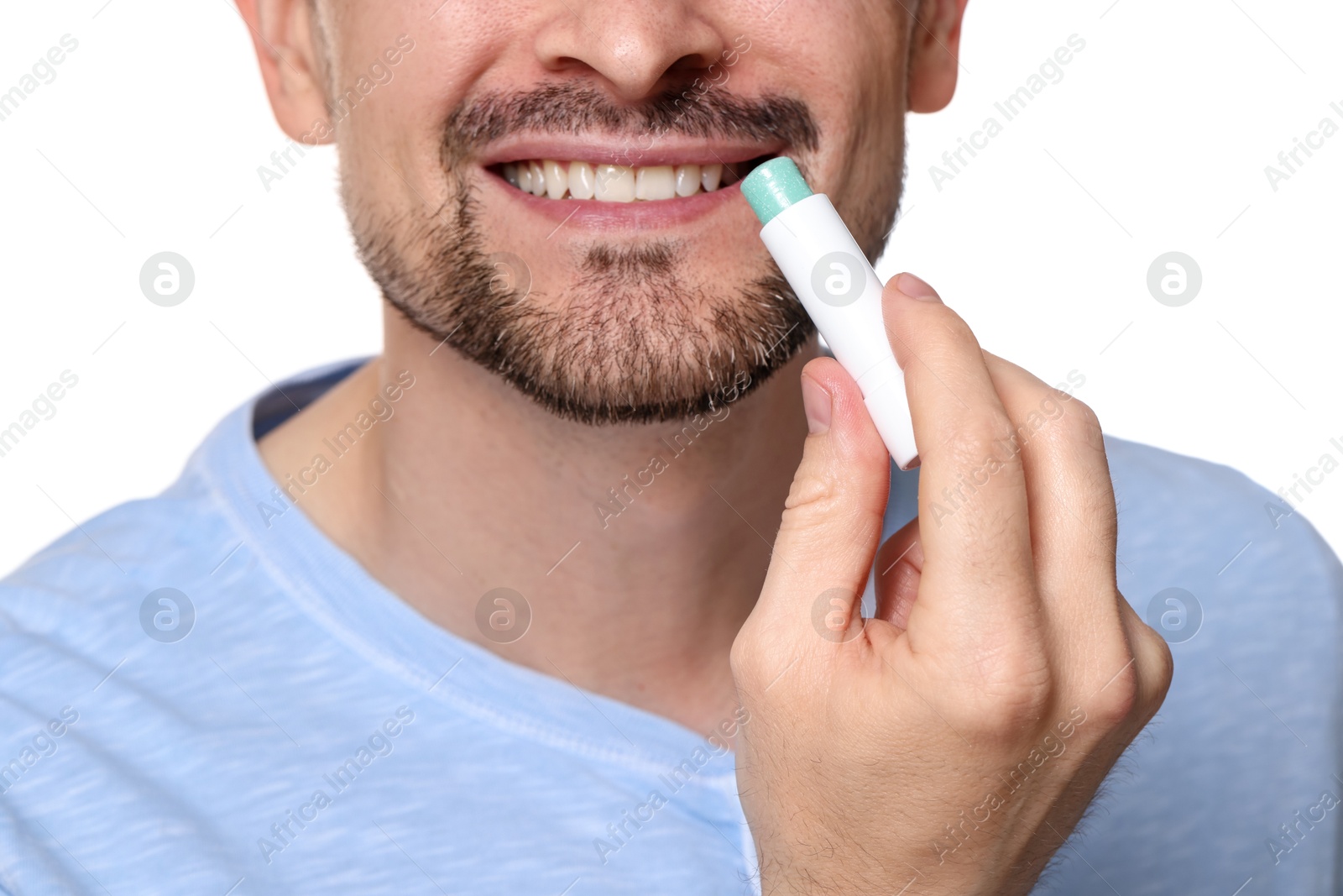 Smiling man applying lip balm onto his lips on white background, closeup Photo of Smiling man applying lip balm onto his lips on white background, closeup
