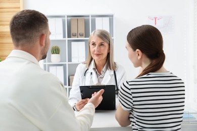 Photo of In vitro fertilization (IVF). Couple having consultation with doctor in reproductive clinic, selective focus