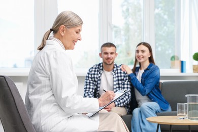 Photo of In vitro fertilization (IVF). Couple having consultation with doctor in reproductive clinic, selective focus