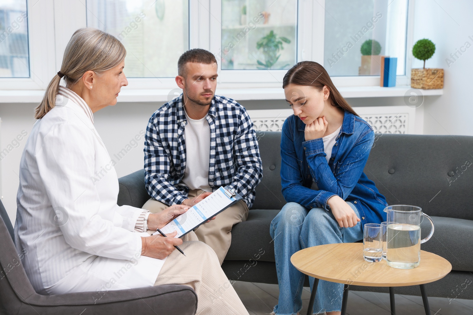 Photo of In vitro fertilization (IVF). Upset couple having consultation with doctor in reproductive clinic