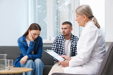 Photo of In vitro fertilization (IVF). Upset couple having consultation with doctor in reproductive clinic
