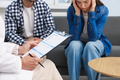 Photo of In vitro fertilization (IVF). Upset couple having consultation with doctor in reproductive clinic, closeup