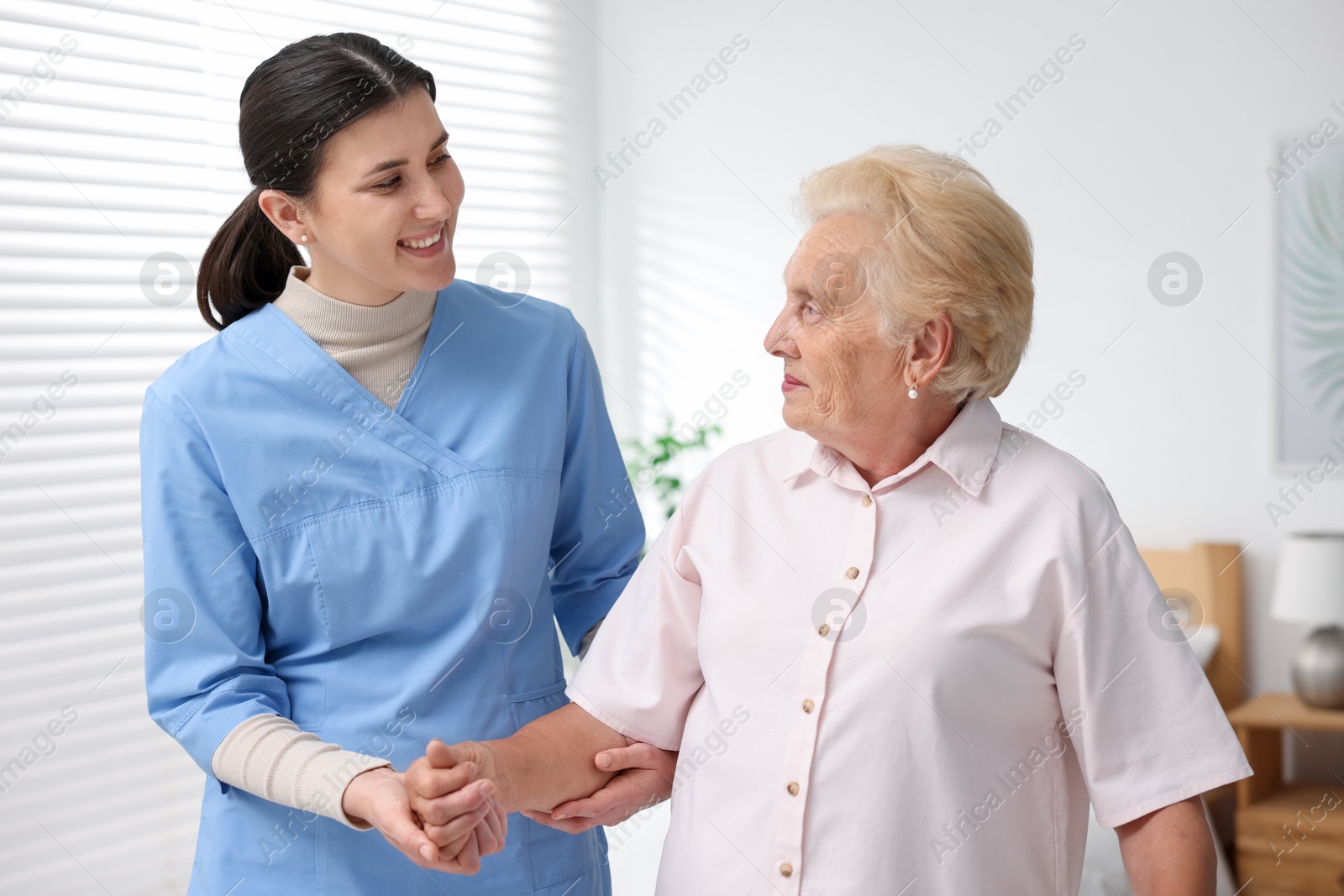 Nurse assisting senior woman indoors. Home health care service Photo of Nurse assisting senior woman indoors. Home health care service
