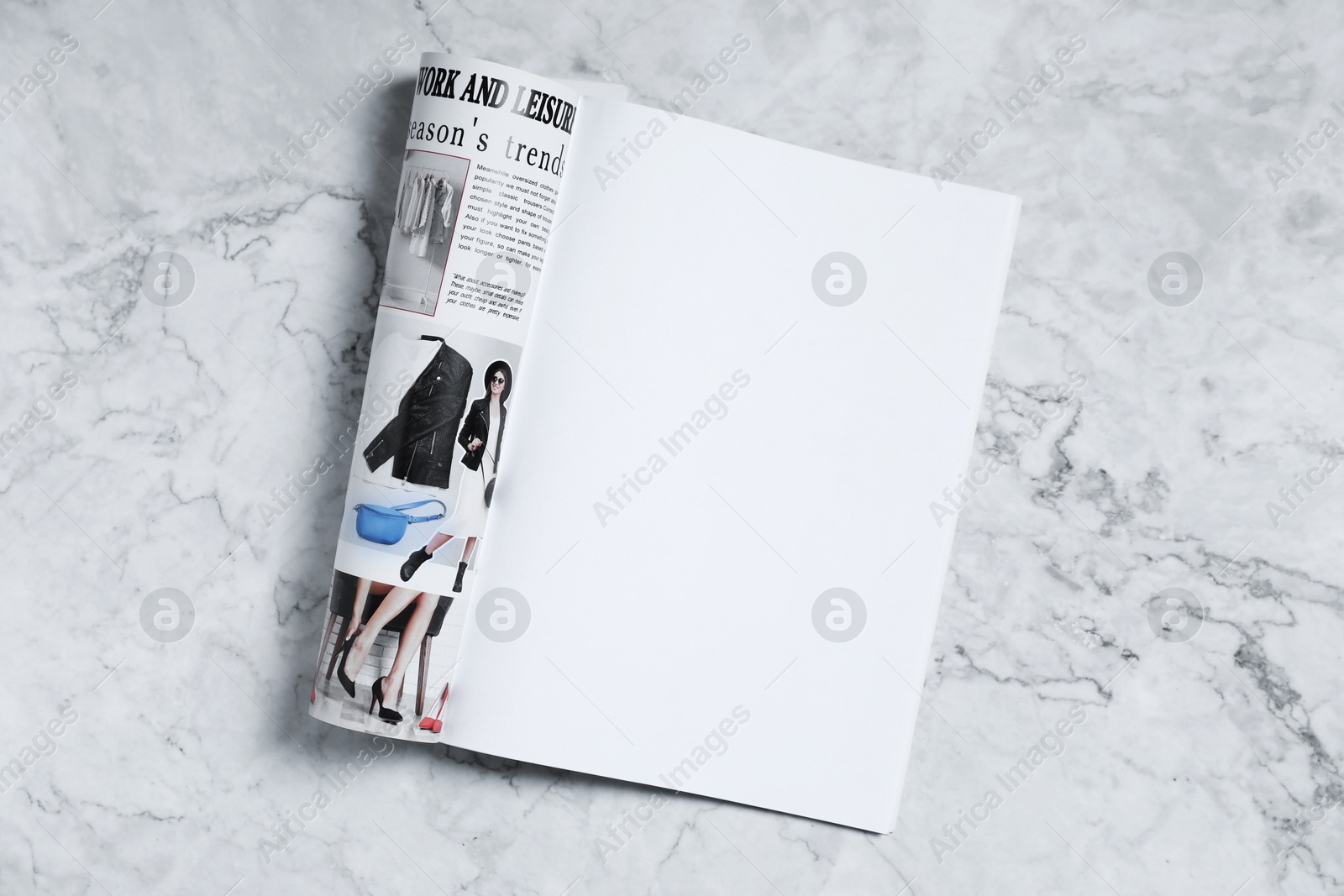 Open magazine on white marble background, top view. Mockup for design Photo of Open magazine on white marble background, top view. Mockup for design