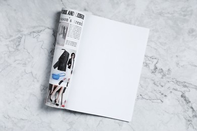Photo of Open magazine on white marble background, top view. Mockup for design