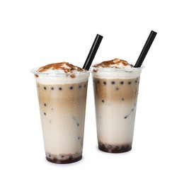 Photo of Tasty milk bubble tea in plastic cups isolated on white