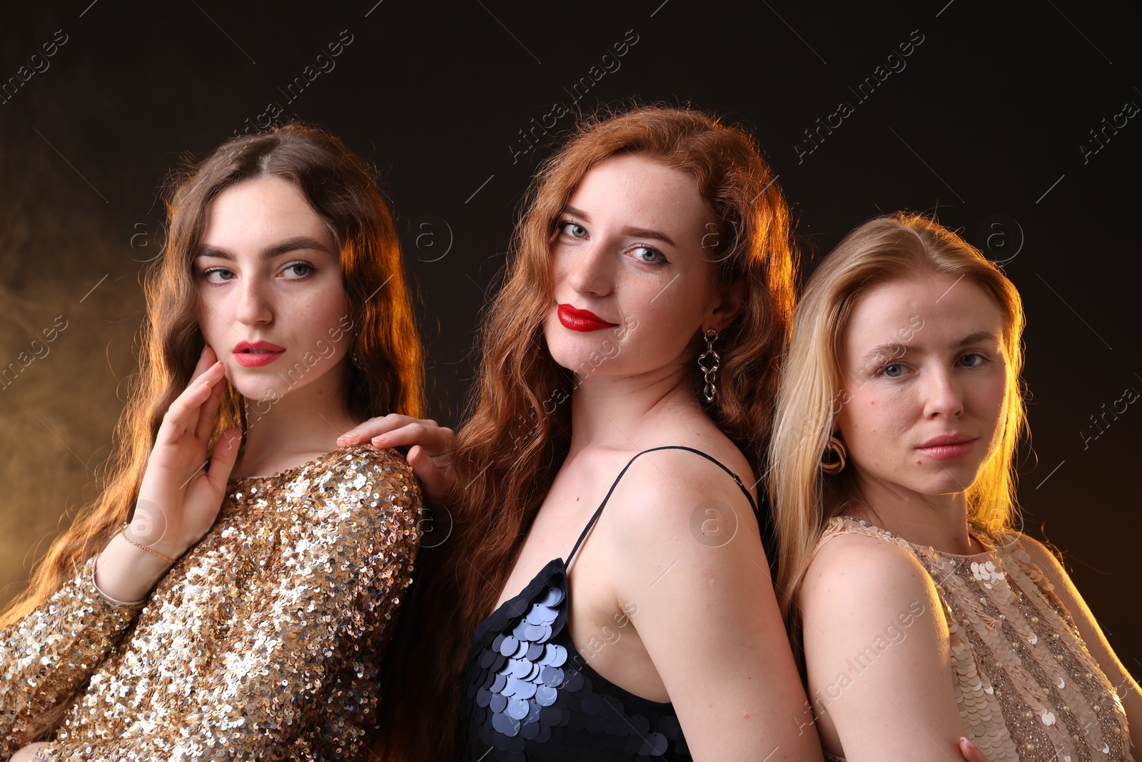 Beautiful women with different hair colors on dark background with smoke Photo of Beautiful women with different hair colors on dark background with smoke