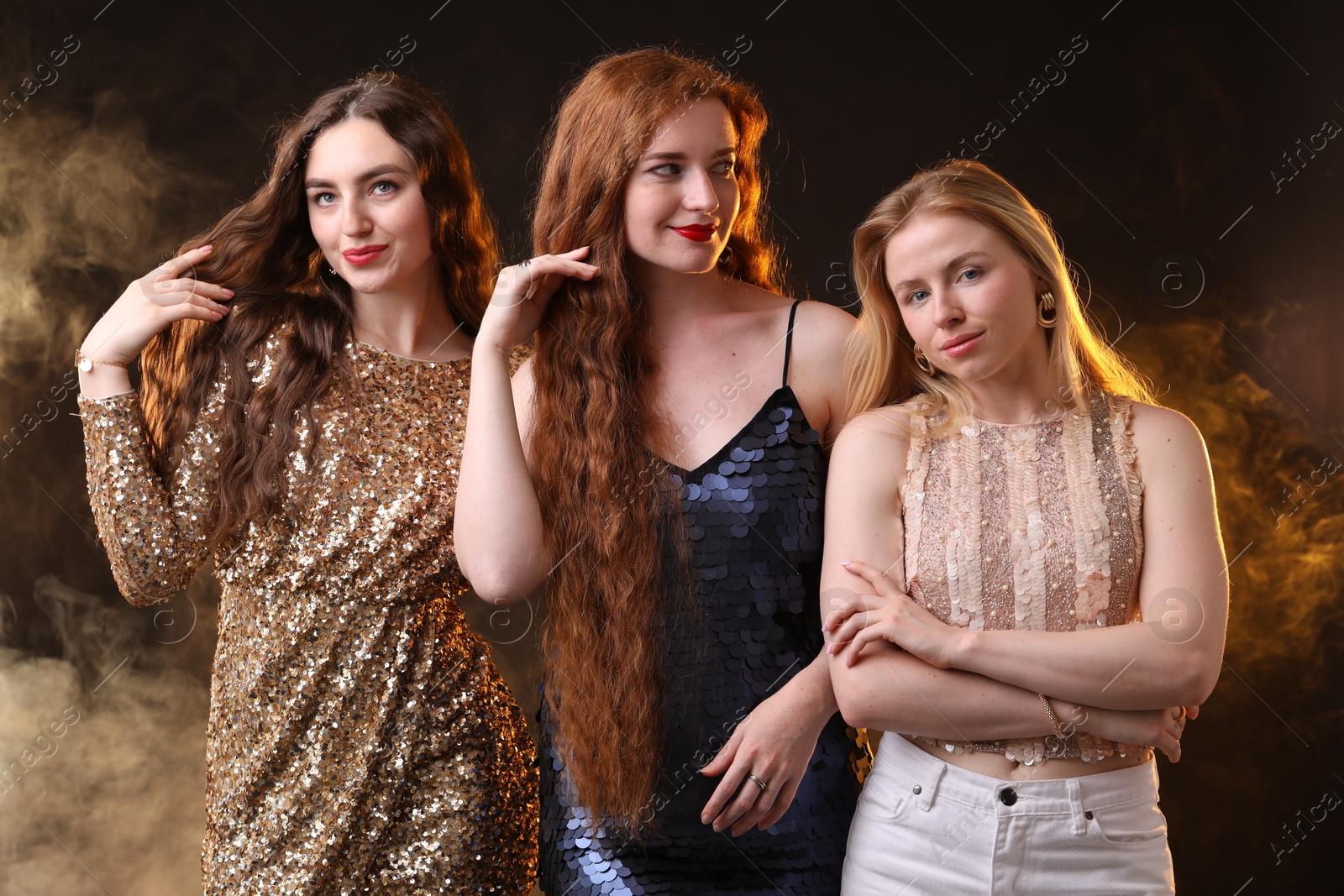 Photo of Beautiful women with different hair colors on dark background with smoke
