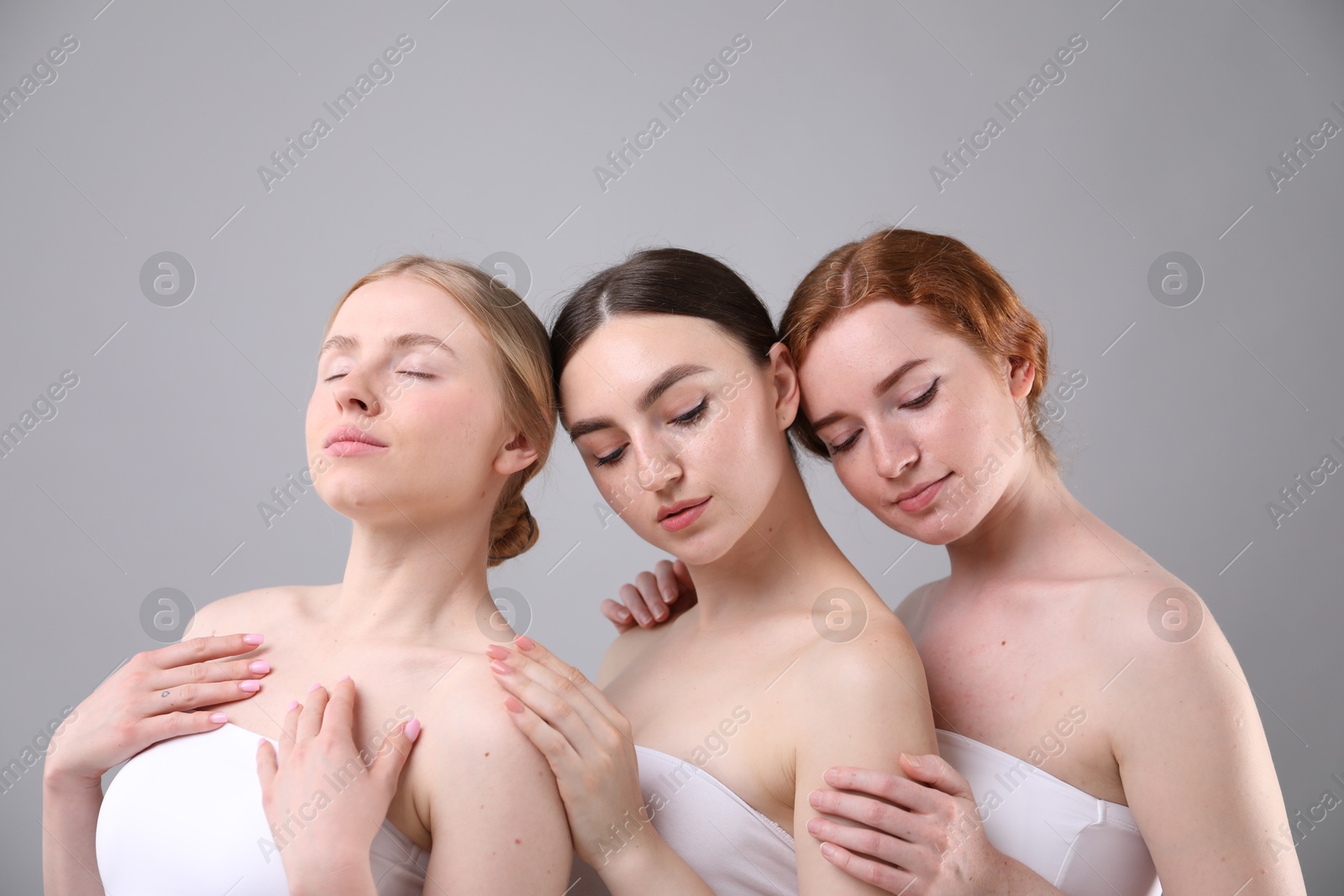 Beautiful women with different hair colors on grey background Photo of Beautiful women with different hair colors on grey background