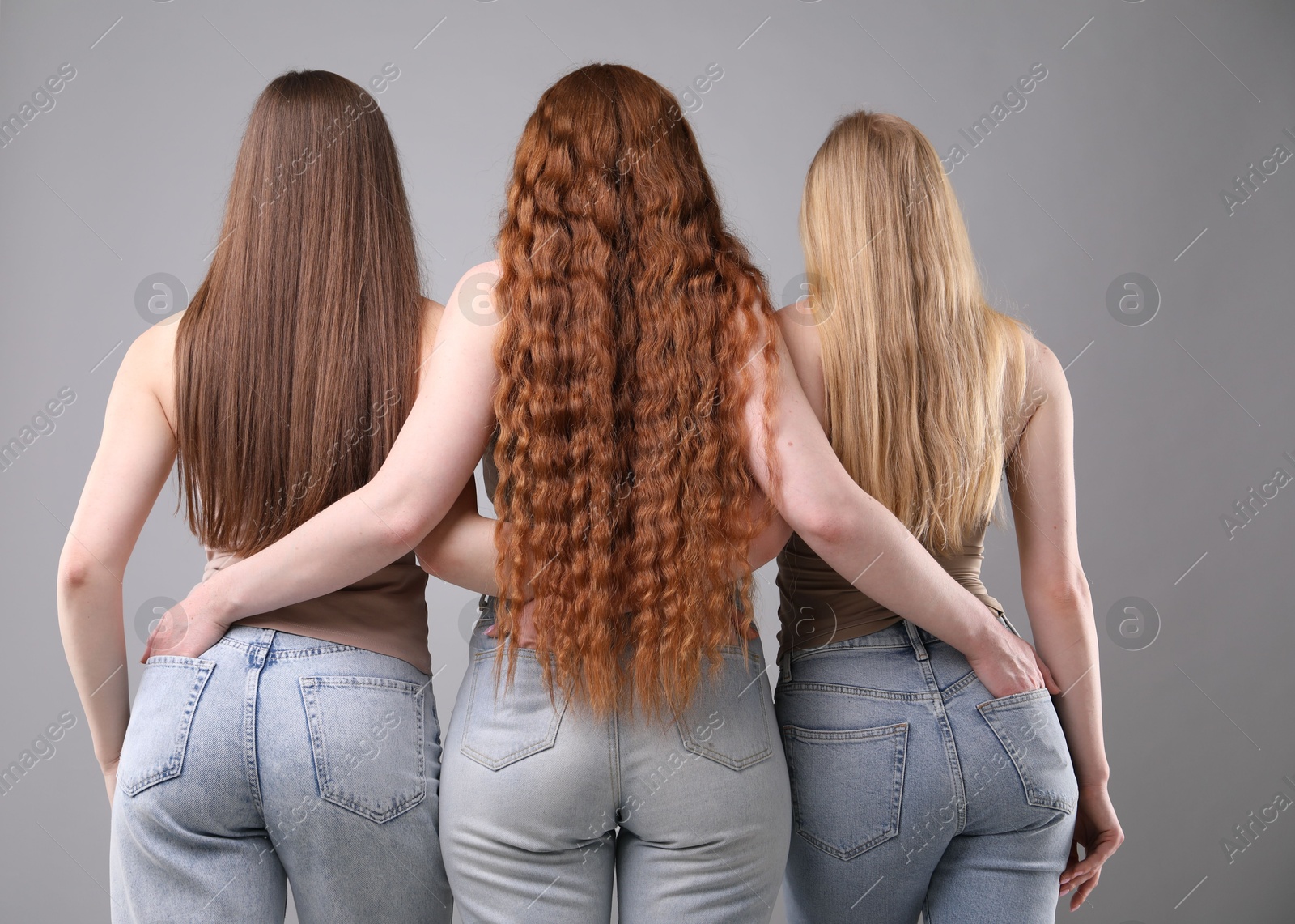 Women with different hair colors on grey background, back view Photo of Women with different hair colors on grey background, back view