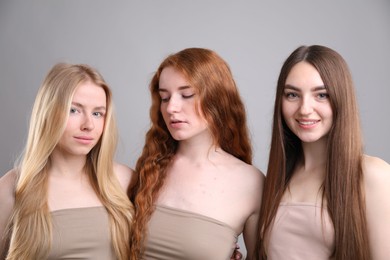 Photo of Beautiful women with different hair colors on grey background