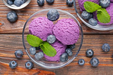 Photo of Tasty sorbet with blueberries and mint served on wooden table, flat lay