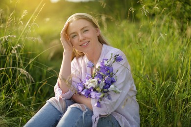 Photo of Beautiful woman with bouquet of wildflowers in meadow