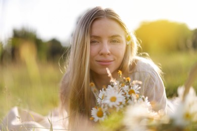 Photo of Beautiful woman with wildflowers in meadow on sunny day