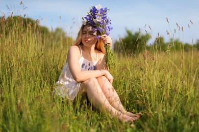 Photo of Beautiful woman with bouquet of wildflowers enjoying sunny day in meadow