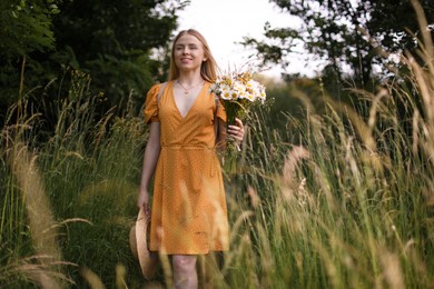 Photo of Beautiful woman with bouquet of wildflowers in meadow