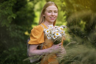 Photo of Happy woman with bouquet of wildflowers in forest
