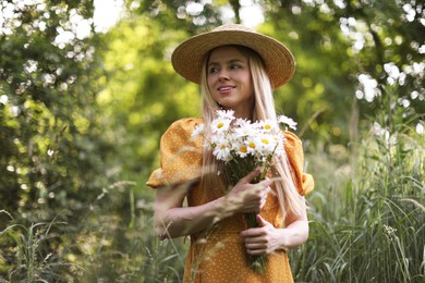 Photo of Beautiful woman with bouquet of wildflowers in forest