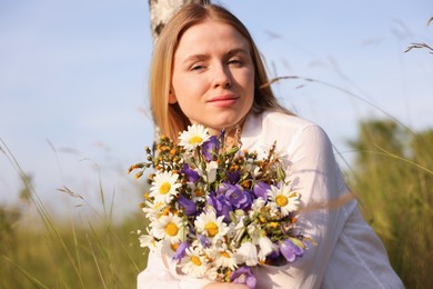 Photo of Woman with bouquet of beautiful wildflowers outdoors on sunny day