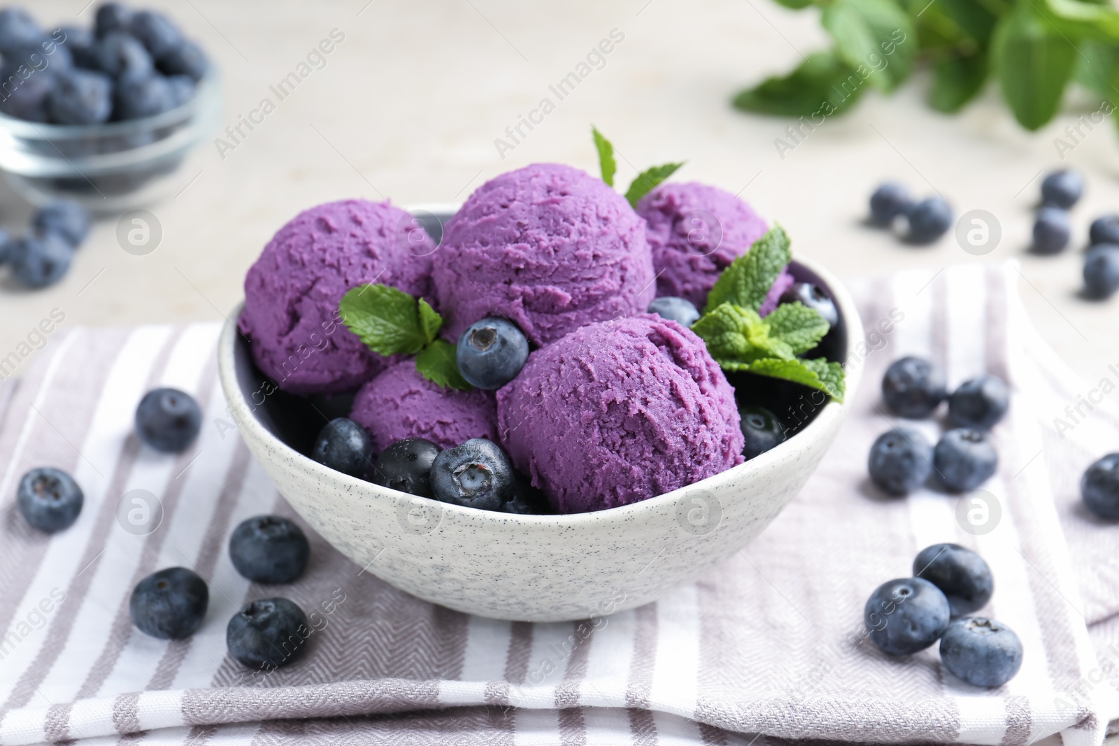 Photo of Tasty sorbet with blueberries and mint on light grey table, closeup