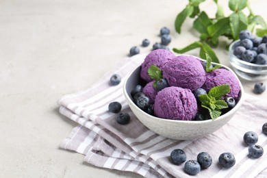 Photo of Tasty sorbet with blueberries and mint on light grey table, closeup. Space for text