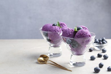 Photo of Tasty sorbet with blueberries and mint on light grey table, closeup. Space for text