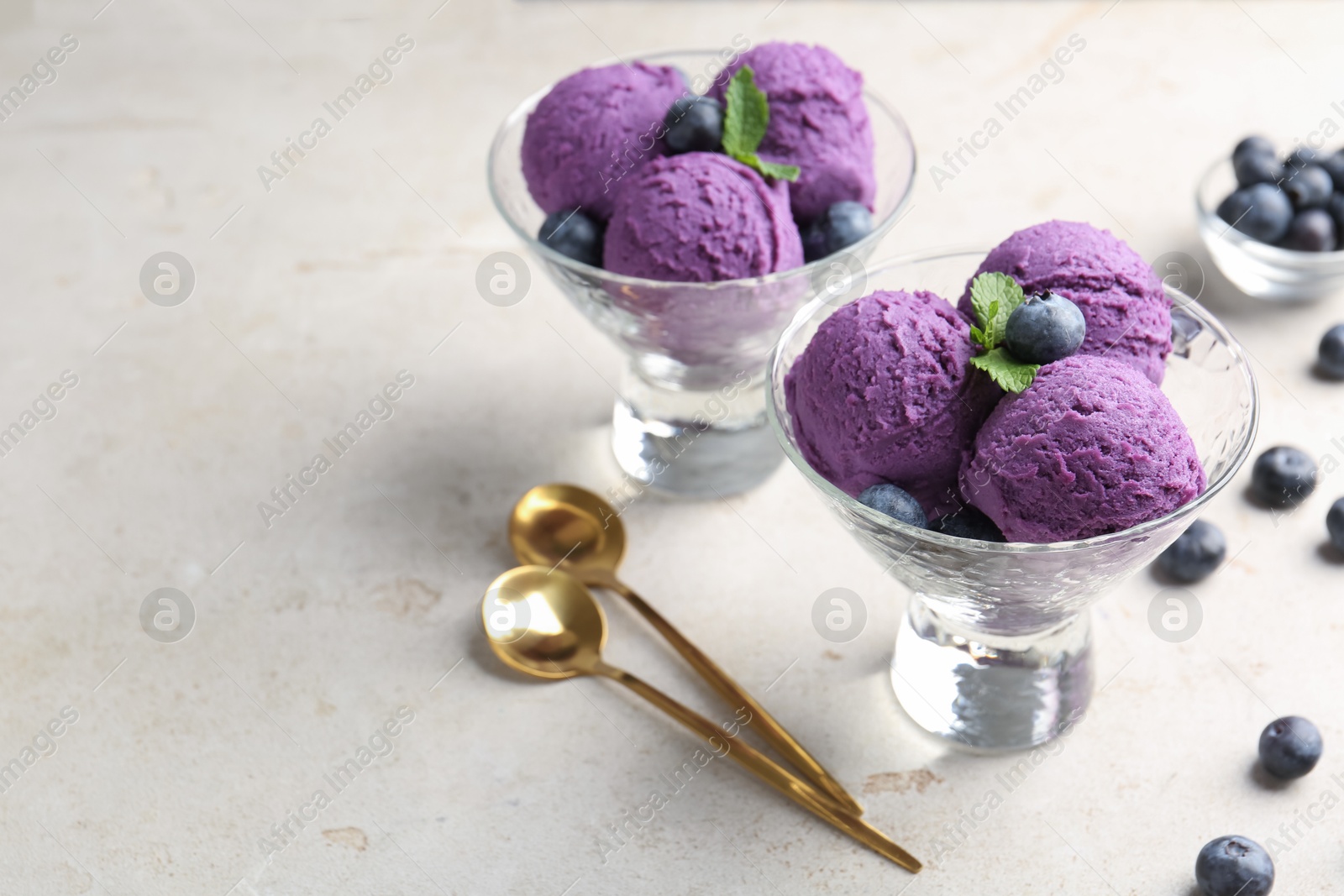 Tasty sorbet with blueberries and mint on light grey table, closeup. Space for text Photo of Tasty sorbet with blueberries and mint on light grey table, closeup. Space for text