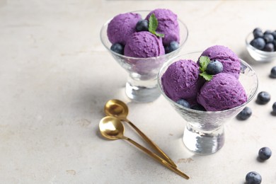 Photo of Tasty sorbet with blueberries and mint on light grey table, closeup. Space for text