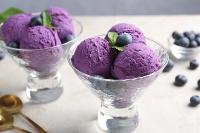 Photo of Tasty sorbet with blueberries and mint on light grey table, closeup