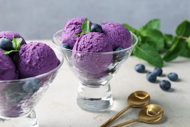 Photo of Tasty sorbet with blueberries and mint on light grey table, closeup