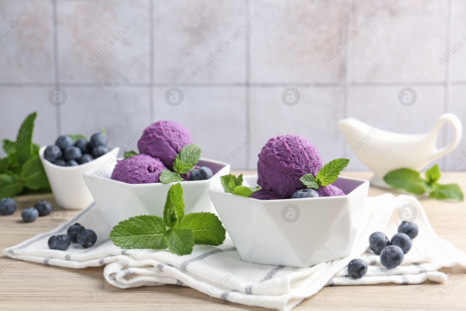 Tasty sorbet with blueberries and mint on wooden table Photo of Tasty sorbet with blueberries and mint on wooden table