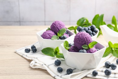 Photo of Tasty sorbet with blueberries and mint on wooden table, closeup. Space for text