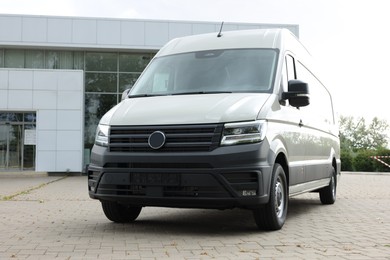 Photo of One white minibus parked on paved road outdoors