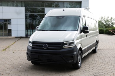 Photo of One white minibus parked on paved road outdoors