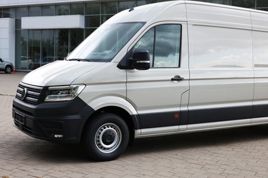 Photo of One white minibus parked on paved road outdoors