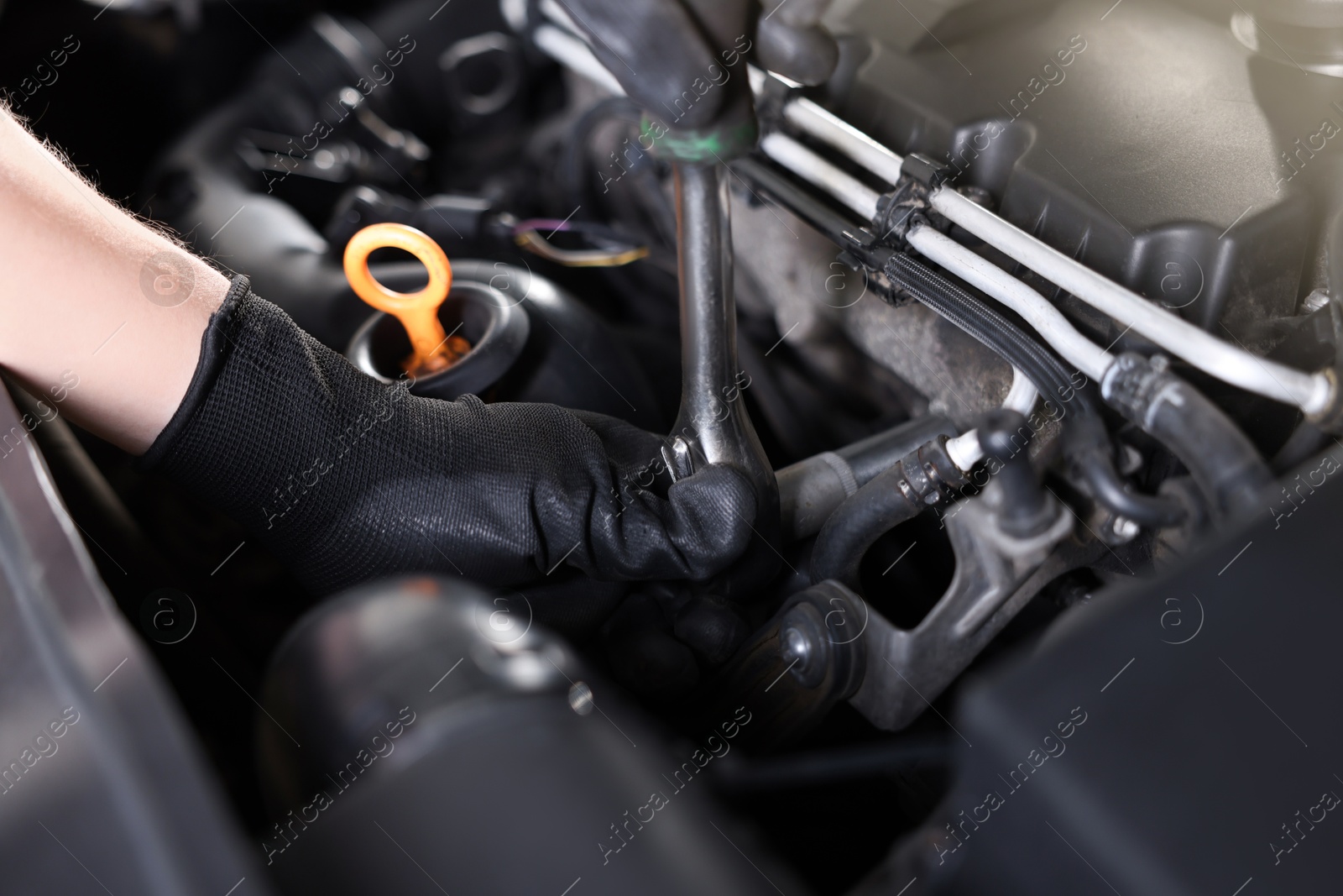 Auto parts. Professional mechanic with torque wrench fixing car indoors, closeup Photo of Auto parts. Professional mechanic with torque wrench fixing car indoors, closeup