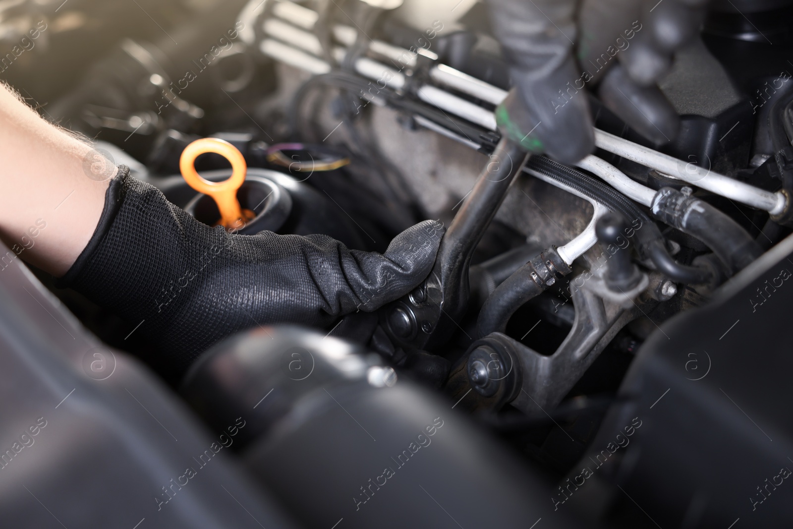 Auto parts. Professional mechanic with torque wrench fixing car indoors, closeup Photo of Auto parts. Professional mechanic with torque wrench fixing car indoors, closeup