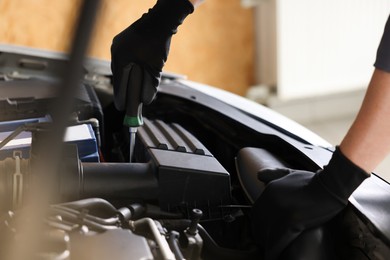Photo of Auto parts. Professional mechanic with screwdriver fixing car indoors, closeup