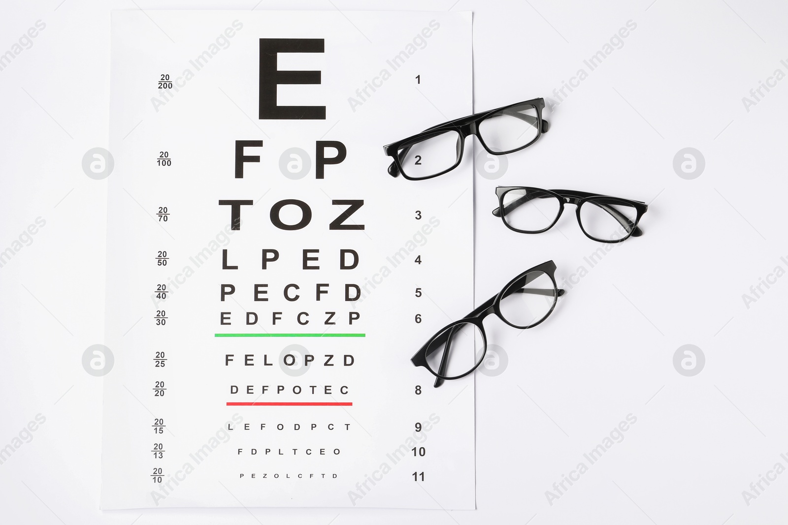 Vision test chart and glasses on white background, flat lay Photo of Vision test chart and glasses on white background, flat lay