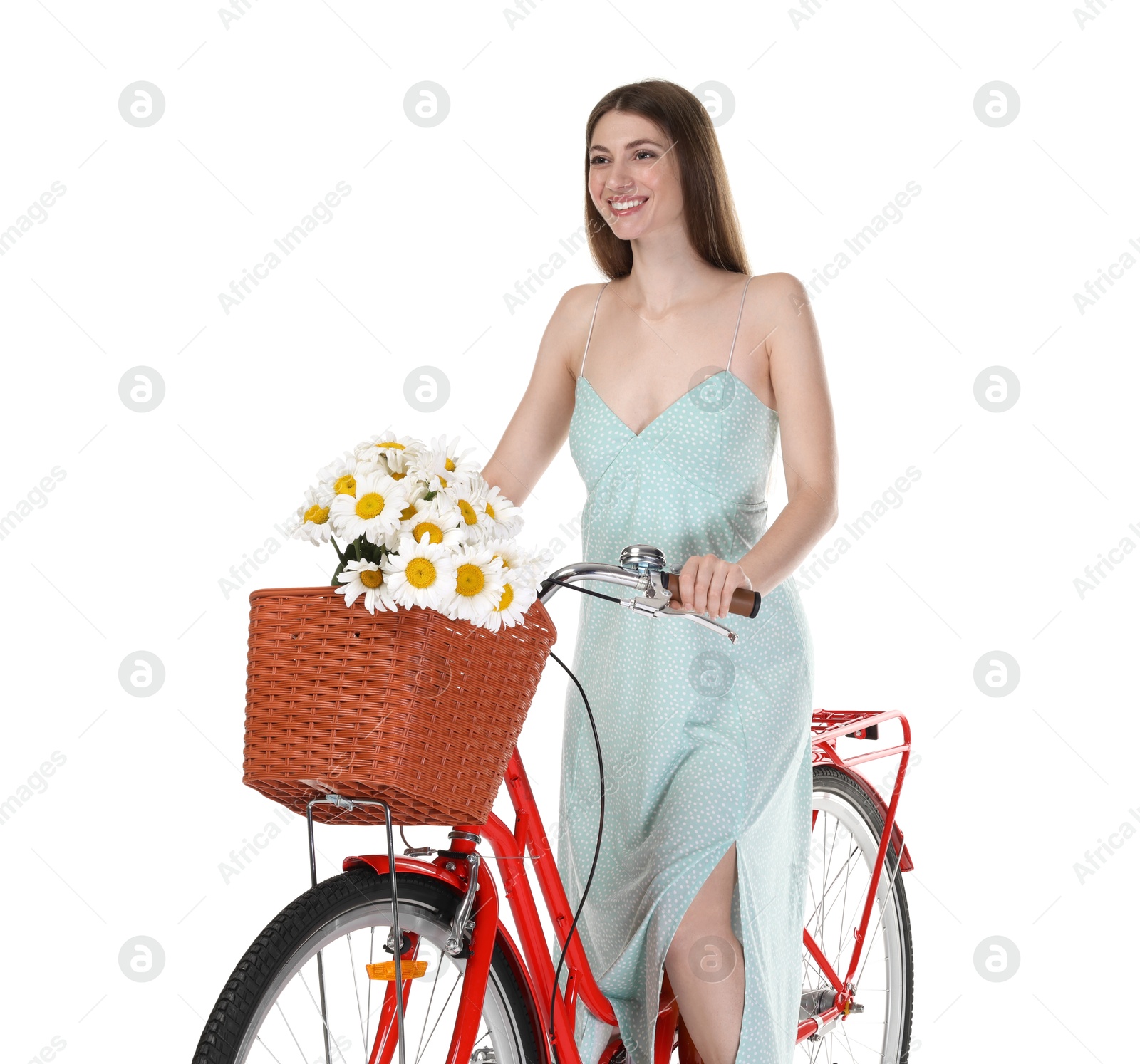 Photo of Smiling woman in dress posing on bicycle with basket of flowers against white background